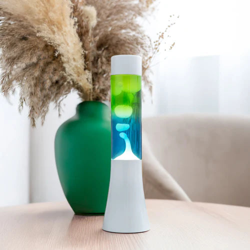 De Fisura Lavalamp met Blauwe & Groene Lava op een tafel.
