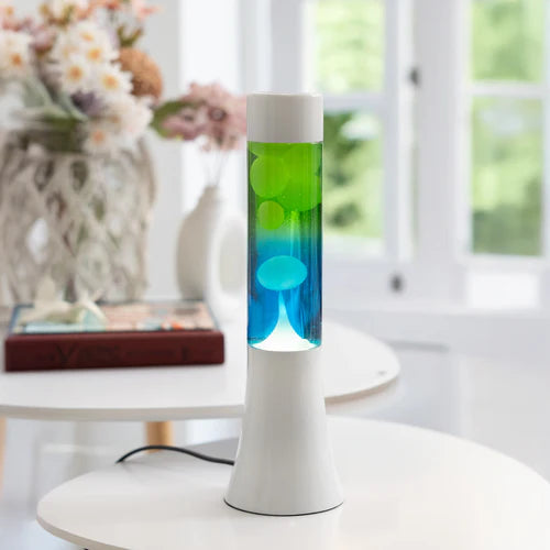 De Fisura Lavalamp met Blauwe & Groene Lava op een witte tafel.
