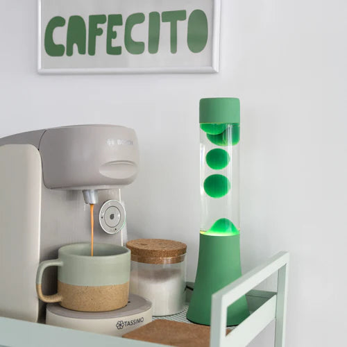 Een foto van de Fisura Groene Lavalamp bij een koffiezetapparaat.