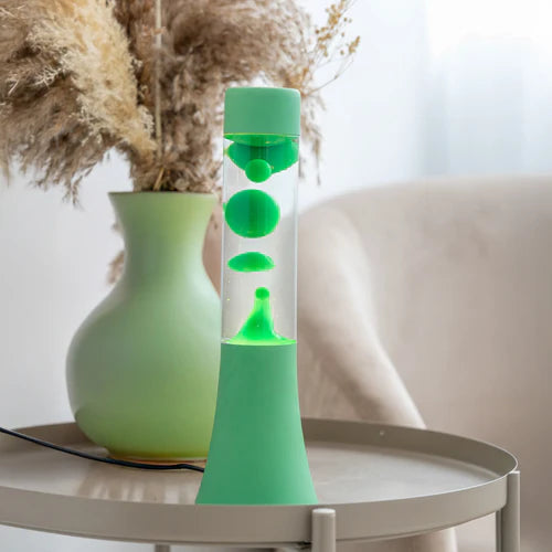 Een foto van de Fisura Groene Lavalamp op een sallontafeltje.