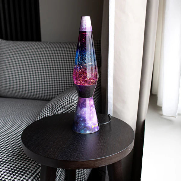 Een foto van de Fisura Kogelvormige Lavalamp met Paarse Lava & Glitter - Galaxy op een salontafeltje.