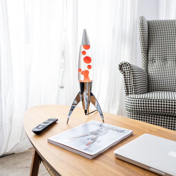 Een foto van de Fisura Raket Lavalamp met Rode Lava - Chrome op een sallontafel in de living.