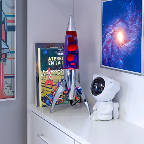 Een afbeelding van de Fisura Raket Lavalamp met Rode & Paarse Lava - Chrome op een kast.