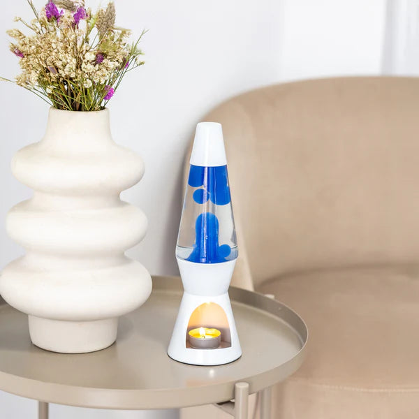 Een afbeelding van de Fisura Theelicht Lavalamp met Blauwe Lava - Wit op een sallontafeltje.