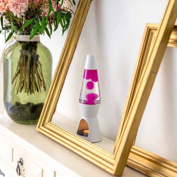 Een foto van de Fisura Theelicht Lavalamp met Roze Lava - Wit op een wand met een gouden kader errond.