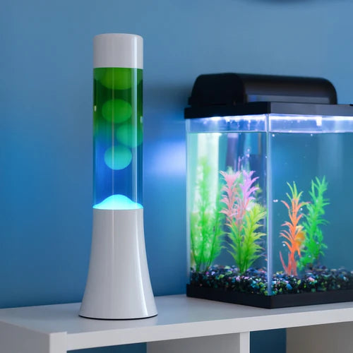 De Fisura Lavalamp met Blauwe & Groene Lava naast een aquarium. 