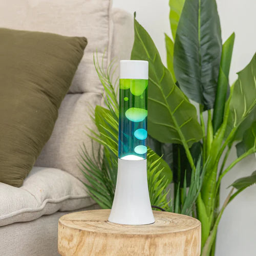 De Fisura Lavalamp met Blauwe & Groene lava op een houten nachtkastje. 