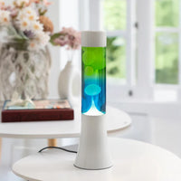 De Fisura Lavalamp met Blauwe & Groene Lava op een witte tafel. 