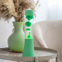 Een foto van de Fisura Groene Lavalamp op een sallontafeltje. 