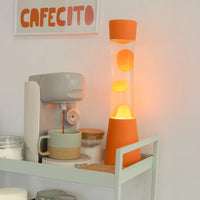 Fisura Grote Design Lavalamp met Oranje Lava - Oranje naast een koffiemachine