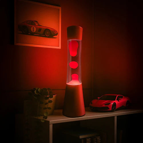 Een foto van de grote rode lavalamp van Fisura in een donkere rode kamer. De lamp licht de kamer op. 