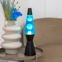 Een foto van de Fisura Kogelvormige Lavalamp met Blauwe Lava - Zwart op een sallontafeltje in de leefruimte. 