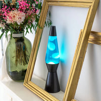 Een foto van de Fisura Kogelvormige Lavalamp met Blauwe Lava - Zwart op een wand met een gouden kader errond.