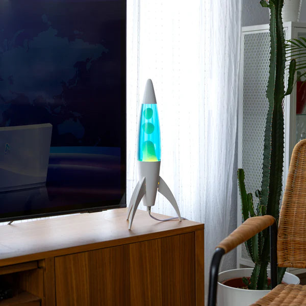 Een foto van de Fisura Raket Lavalamp met Blauwe Lava - Chrome naast de televisie. 