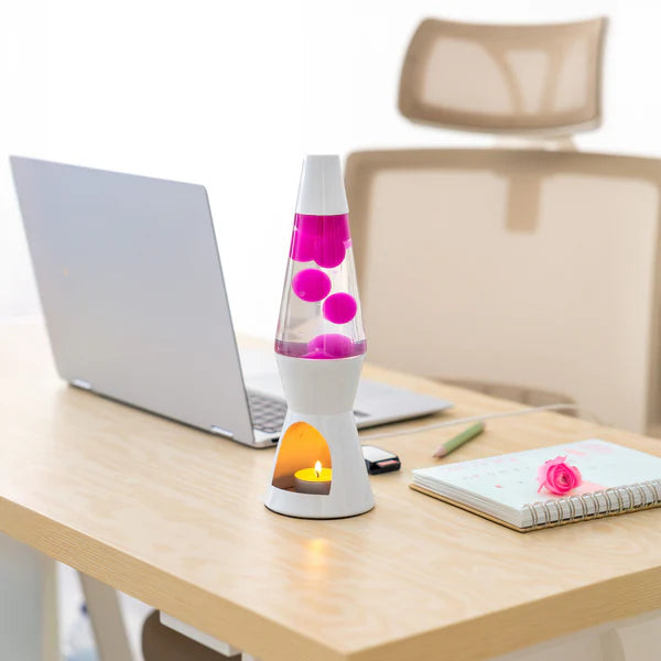 Een foto van de Fisura Theelicht Lavalamp met Roze Lava - Wit op een tafel naast een laptop. 